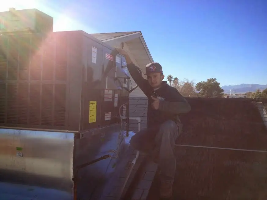 HVAC technician performing Air Duct Cleaning on a rooftop unit in Robinwood